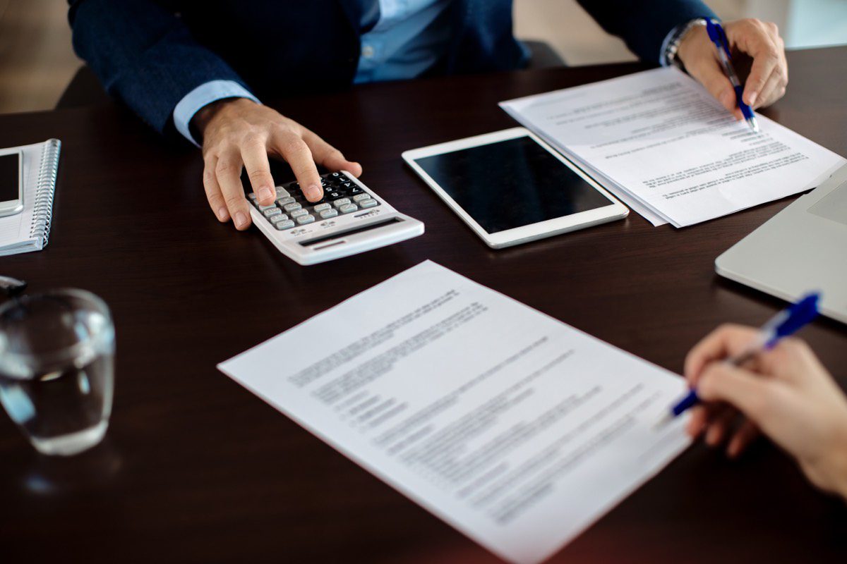 Consultor financeiro revisando documentos com um cliente