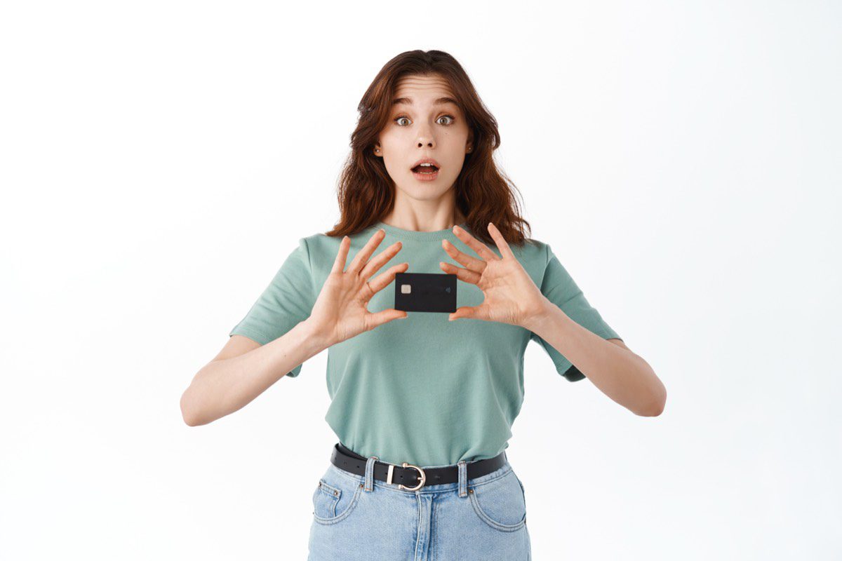 Adolescente animada mostrando seu primeiro cartao de credito